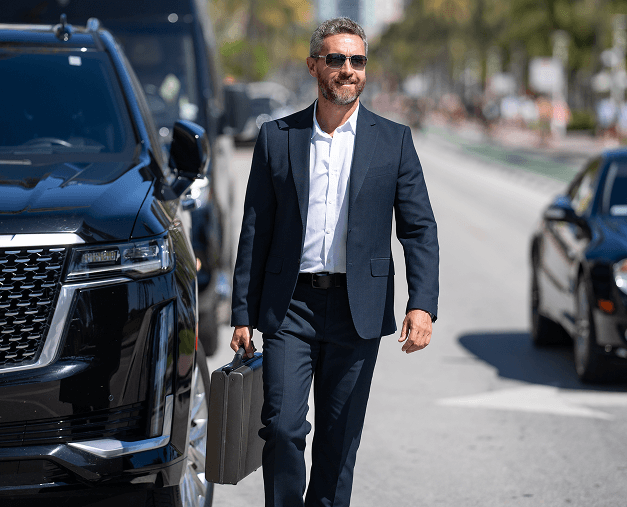 Businessman walking, briefcase, sunny street.