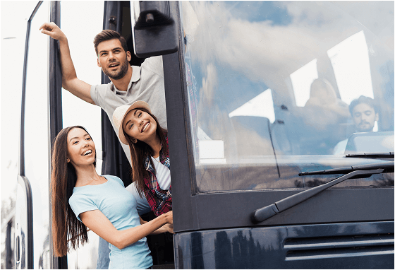 Happy friends boarding a tour bus.