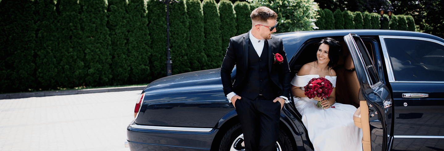 Happy wedding couple in limousine.