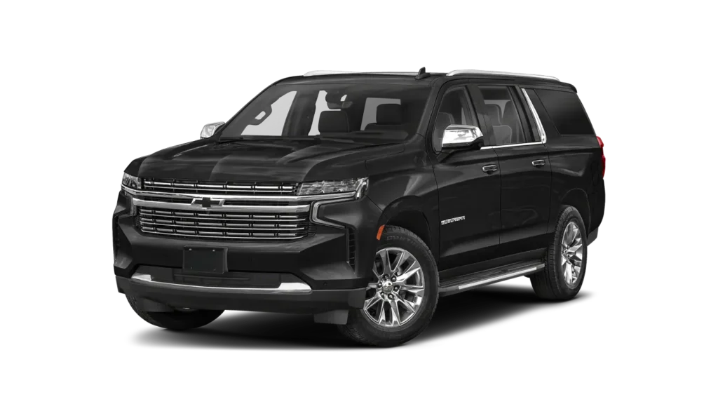 Front-right three-quarter view of a black Chevrolet Suburban SUV with a chrome grille and large chrome wheels.