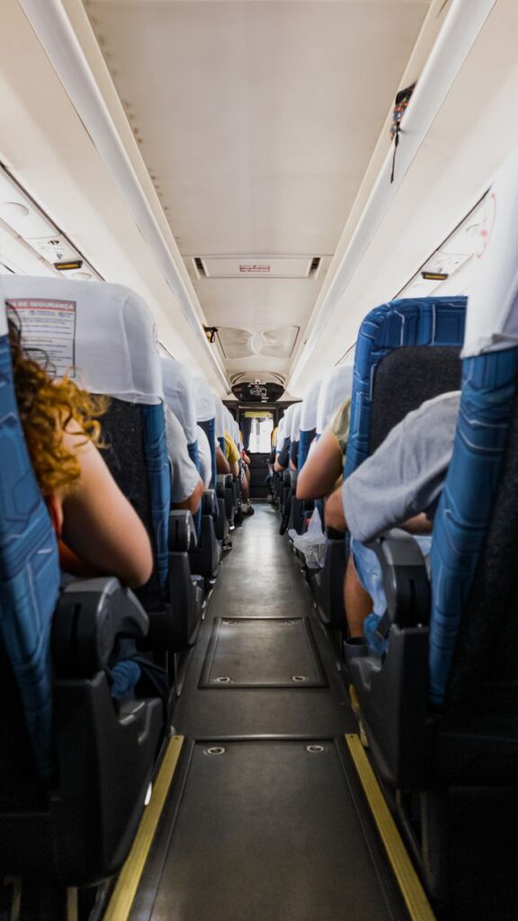 Passengers seated on a bus during a daytime journey, capturing a travel atmosphere.